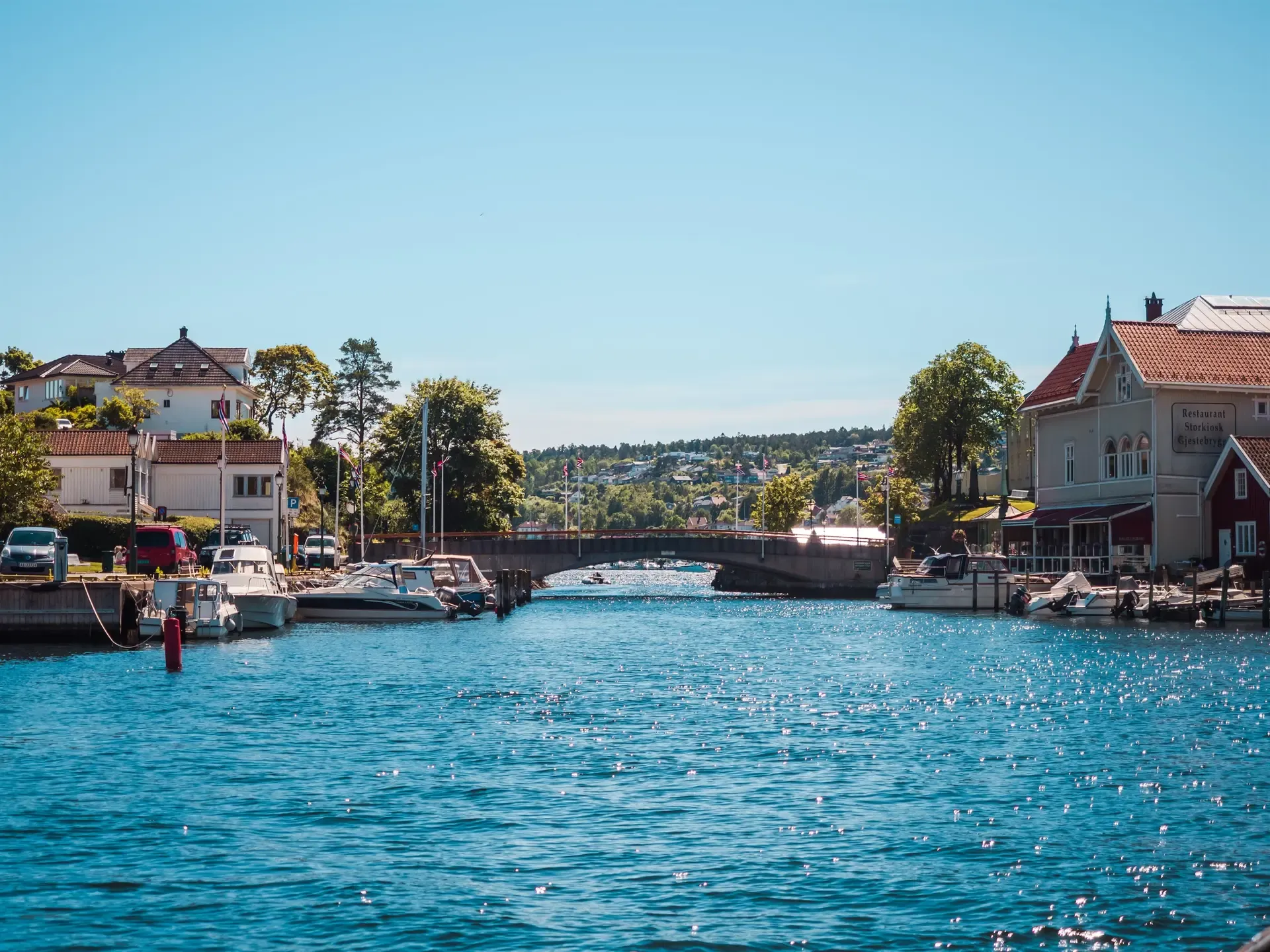 Brevik havn med båter og hvitmalte hus langs kanalen